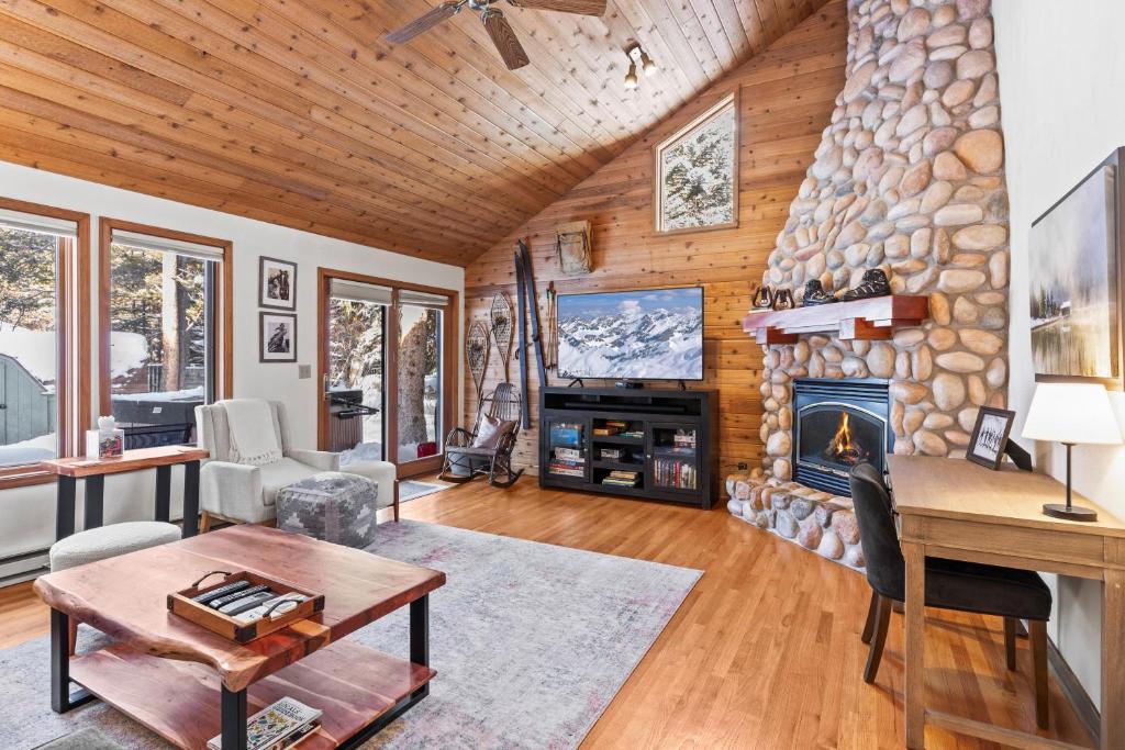 a living room with a stone fireplace and a tv at Abode at Fish Creek in Wilson