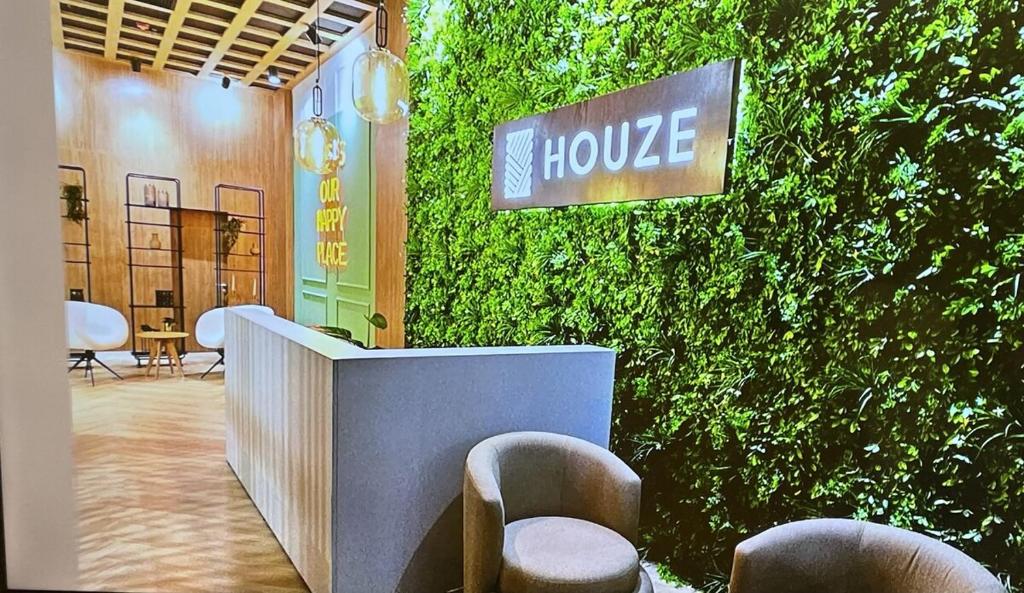 a lobby with a green wall with chairs and a house sign at Lujoso Departamento con Garage in Caña de Castilla