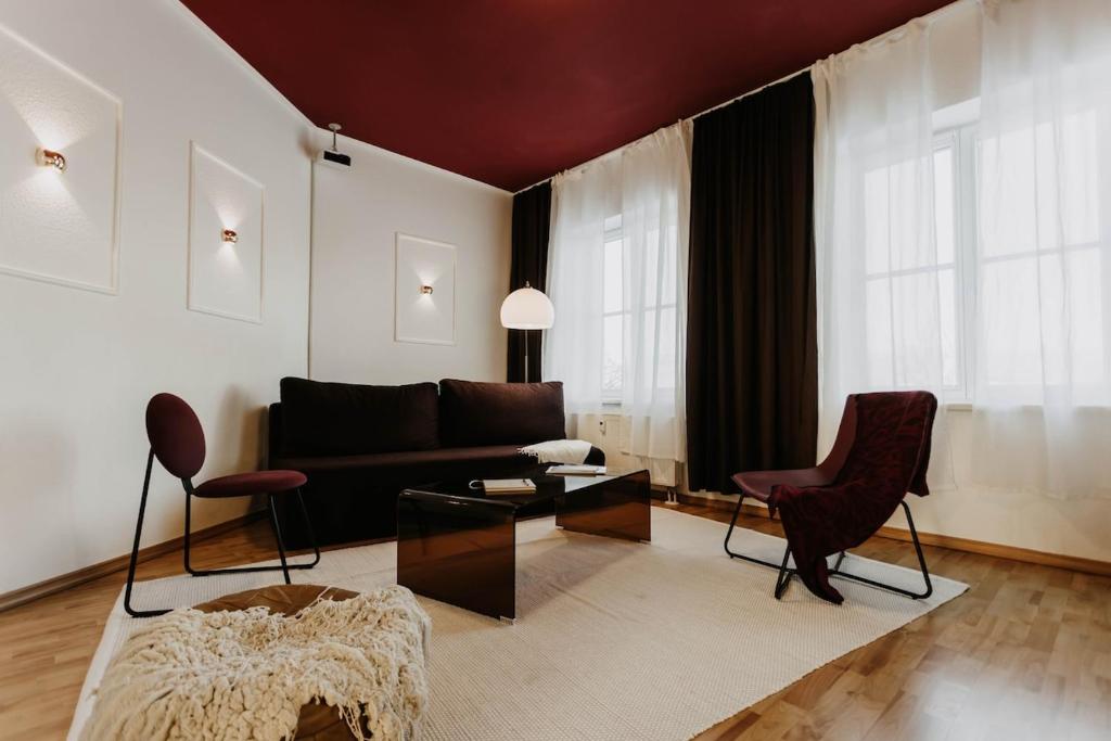a living room with a black couch and chairs at Designer Loft am Dessauer Hauptbahnhof in Dessau