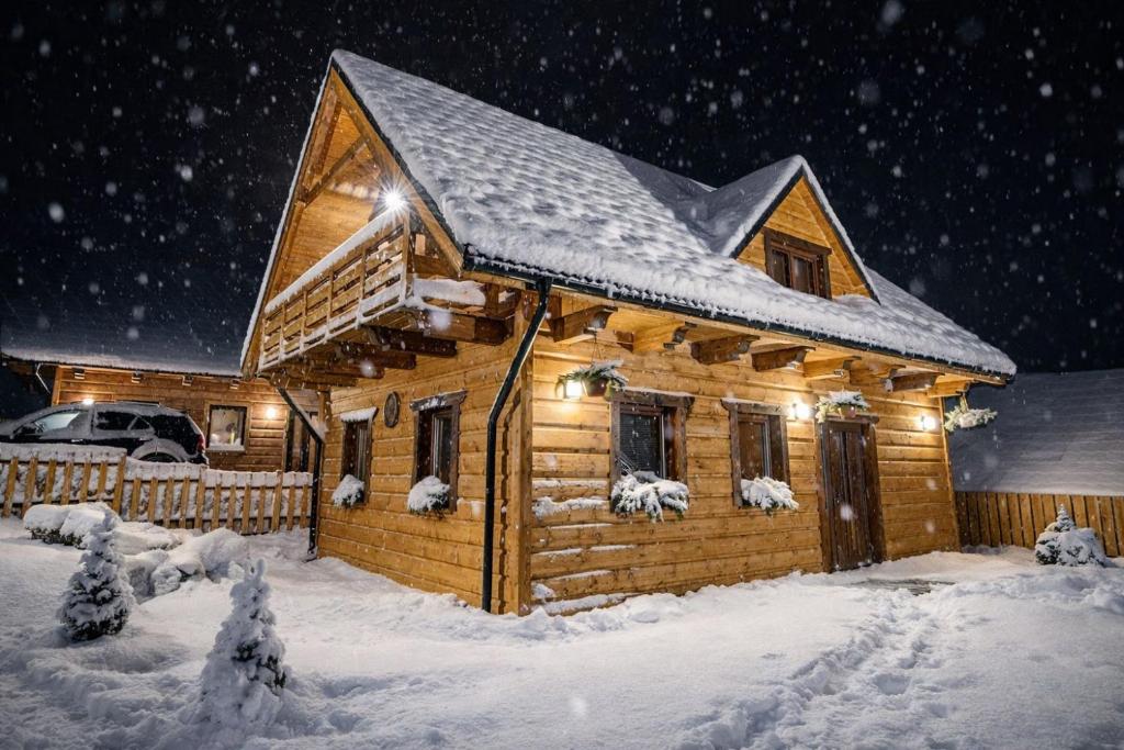 a log cabin with snow on the roof at Chata Visit Telgárt - Telgárt Resort in Telgárt