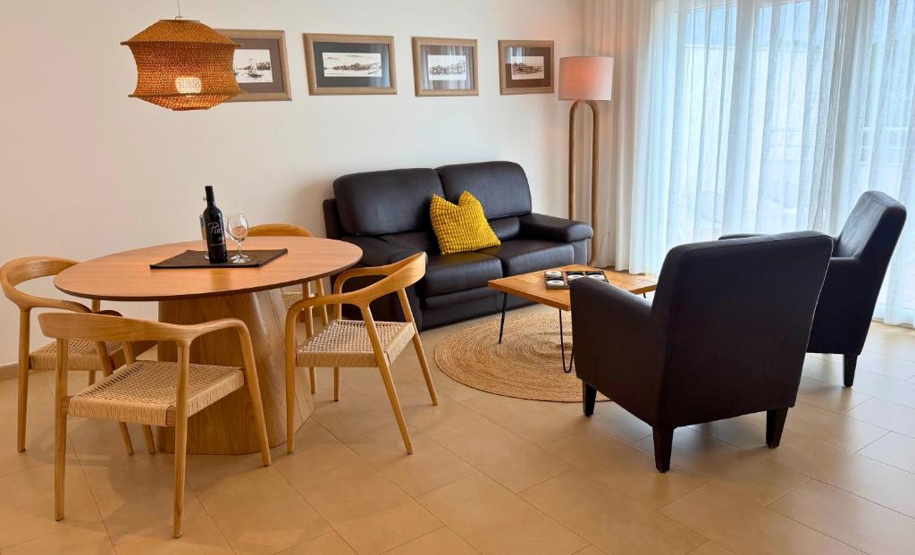 een woonkamer met een bank, een tafel en stoelen bij Pine Tree Apartments - Praia da Coelha - Albufeira in Albufeira
