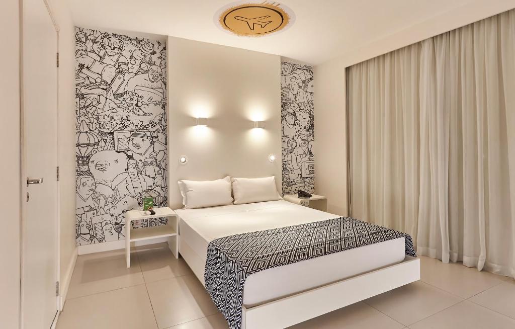 a bedroom with a white bed and a black and white wall at Nacional Inn Palmas in Palmas