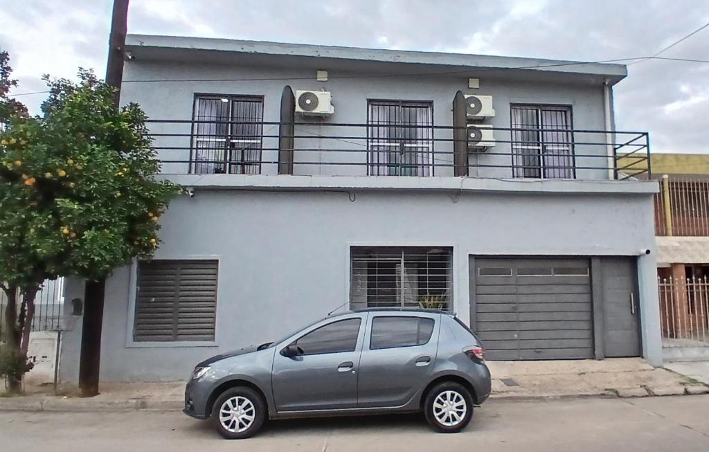 a silver car parked in front of a white house at Tempo Suites in Córdoba