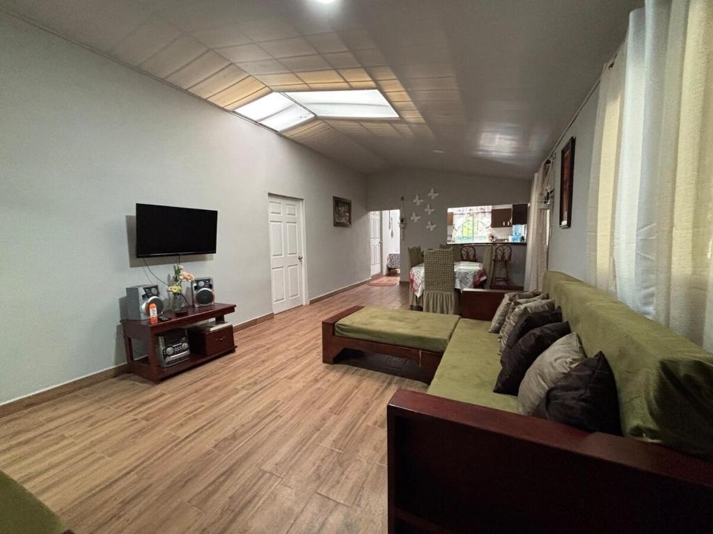 a living room with a couch and a flat screen tv at Quinta Los 3 Tesoros in San Francisco Amatepe