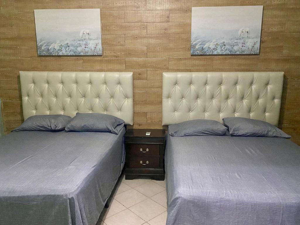 two beds sitting next to each other in a room at Horus Suite Apartamento in San Pedro Sula