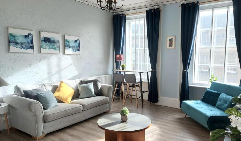 a living room with a couch and a table at Spacious Victorian Apartment in Edinburgh City in Edinburgh