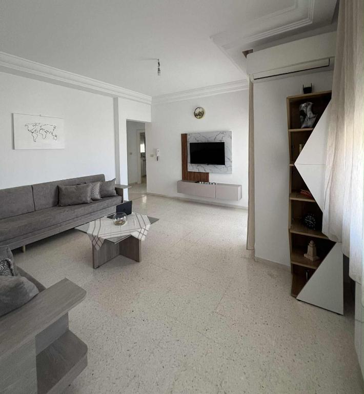 a living room with a couch and a tv at Appartement central et spacieux in Monastir