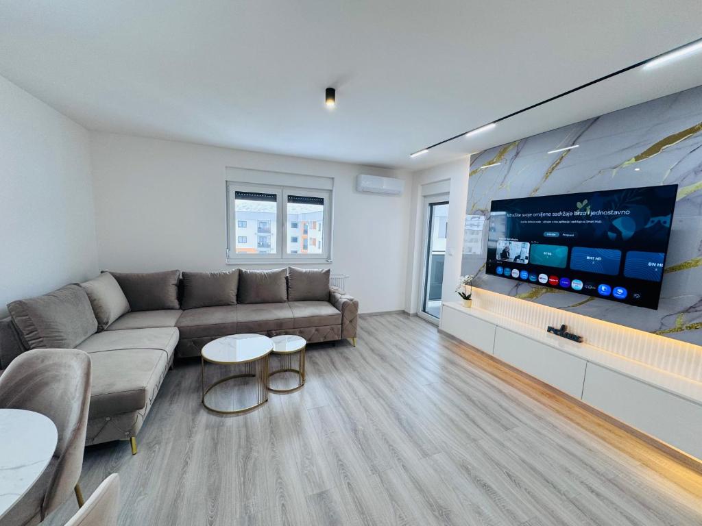 a living room with a couch and a flat screen tv at Apartman Jaćimović in Doboj