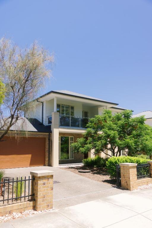 a large white house with trees in front of it at Hampton Luxe Designer Retreat with Park Views in Melbourne