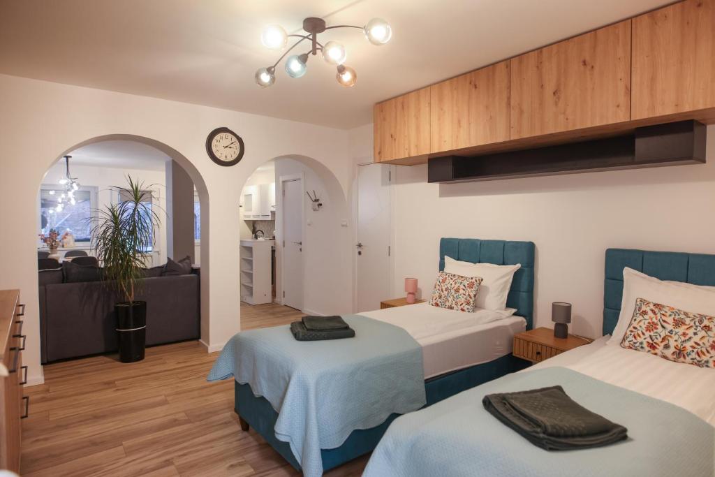 a bedroom with two beds and a living room at Lazar Apartman in Čantavir