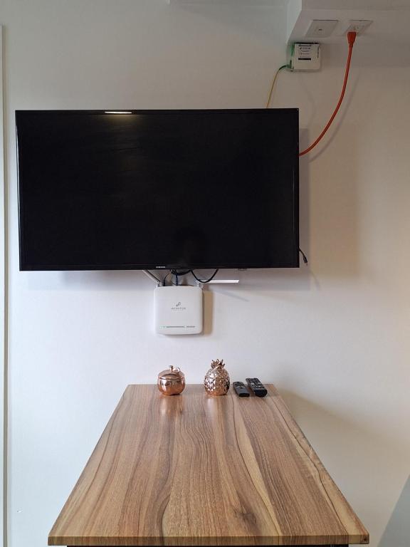 a flat screen tv on a wall with a wooden table at Flamingo zona 4 in Guatemala