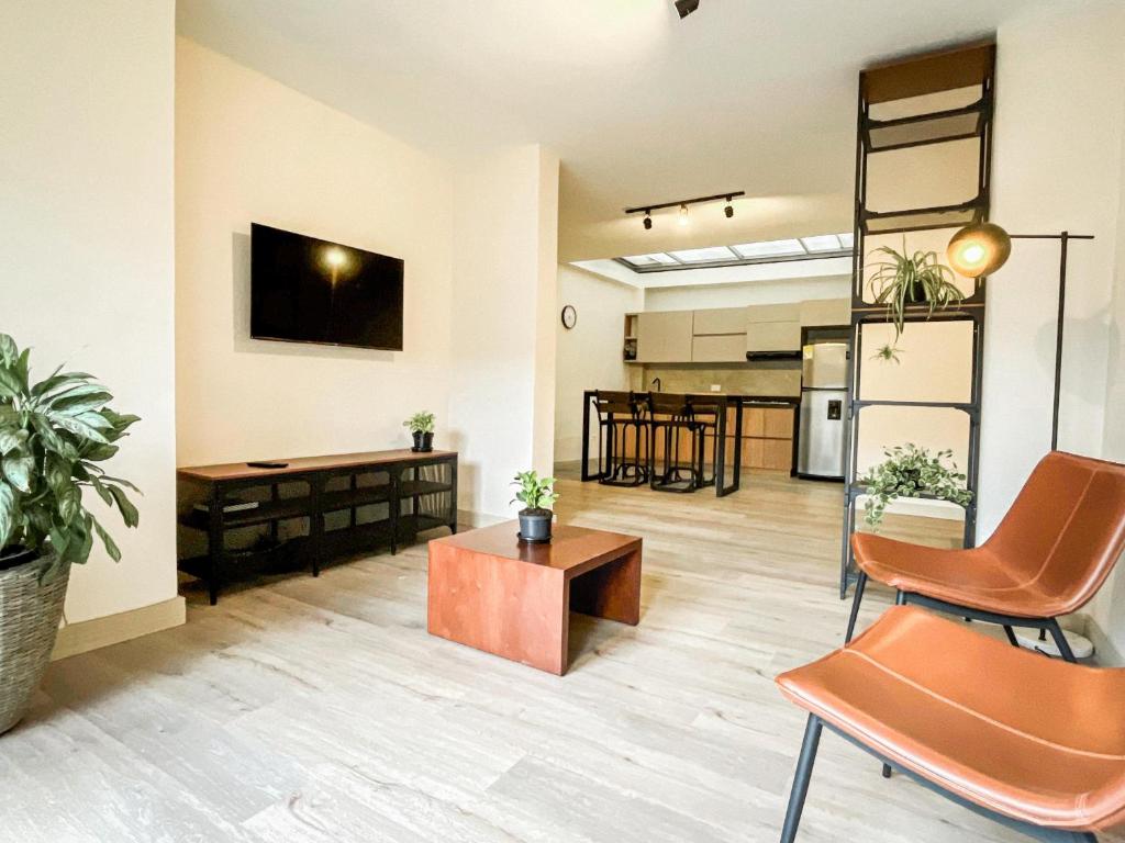 an open living room with a table and chairs at Vive Medellin apartamento in Envigado