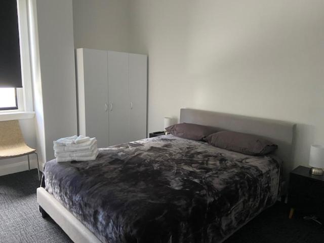 a bedroom with a large bed in a room at Commercial Hotel Parkes in Parkes