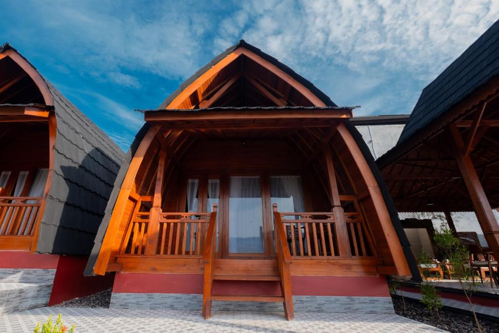 a small house with a porch and a balcony at Villa Kartikasari in Munduk
