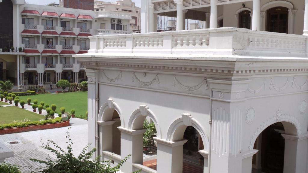 a white building with arches in front of a building at Hotel Surya, Kaiser Palace in Varanasi