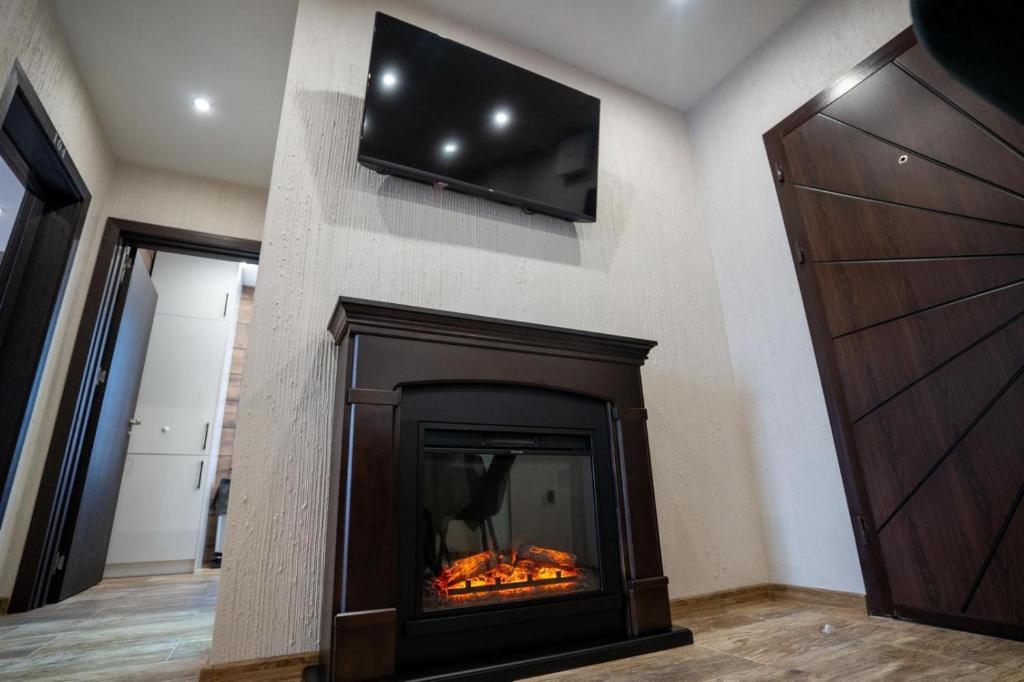 a fireplace with a flat screen tv on a wall at Къща за гости Бъчвата in Elkhovo
