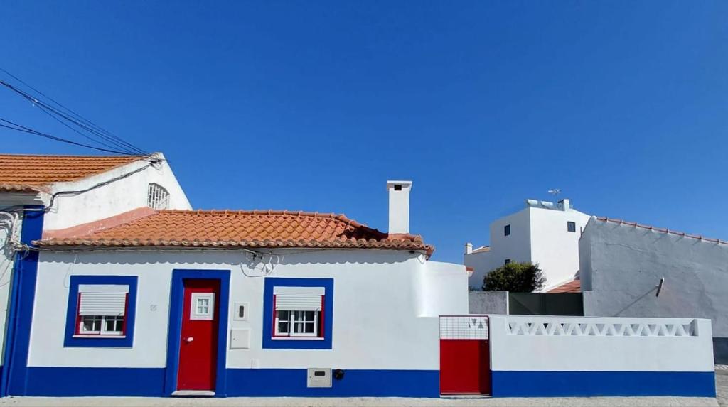 a blue and white house with red and blue doors at Casa do Ferro de Engomar in Samouco