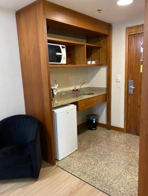 a small kitchen with a sink and a microwave at Lindo flat Grand Mercoure triplo in Brasília