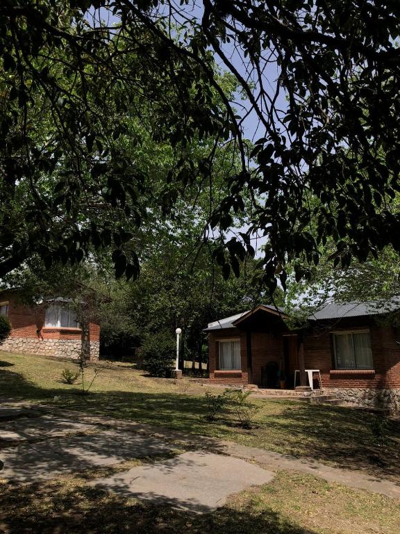 a small brick house in the middle of a yard at Balcón del Cerro Cabañas in La Falda