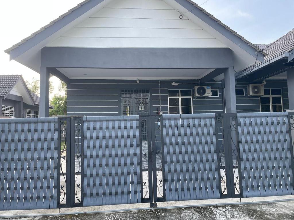 een blauw hek voor een huis bij Bait al-Qamar in Kampong Wakaf Tengah