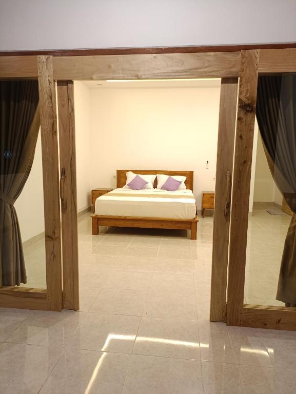 a bedroom with a bed with two pillows at Dharma Yoga Guest House Amed in Amed
