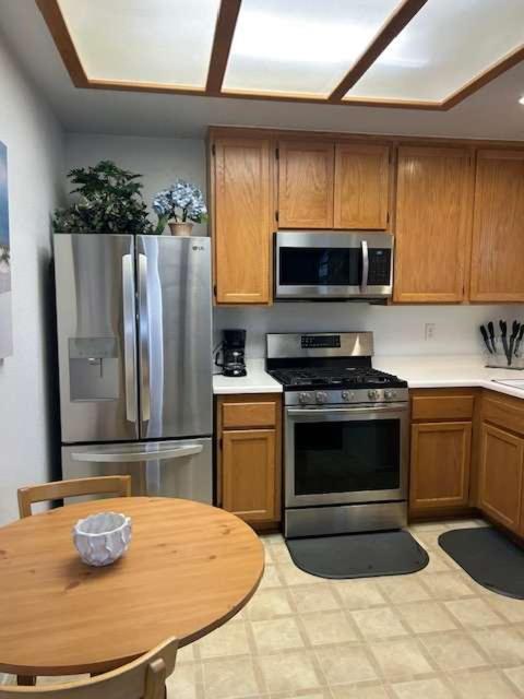 a kitchen with stainless steel appliances and a wooden table at Low Tide Lounge in Oceano