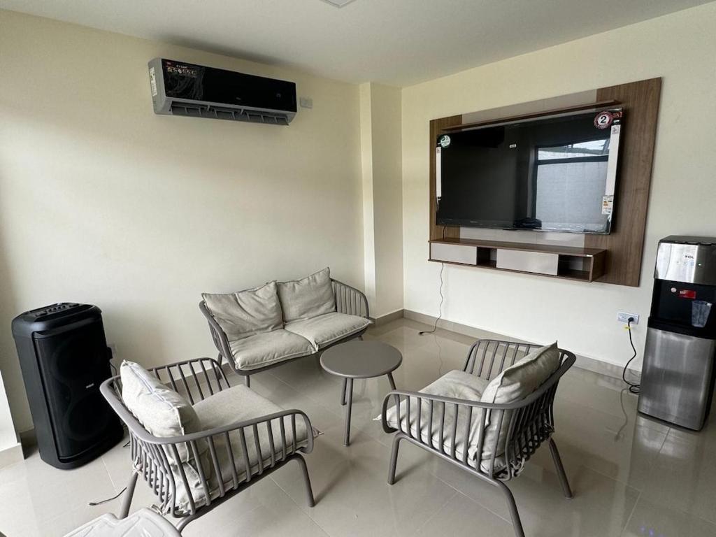 a living room with a tv and chairs and a table at Confortable casa independiente in Crucita