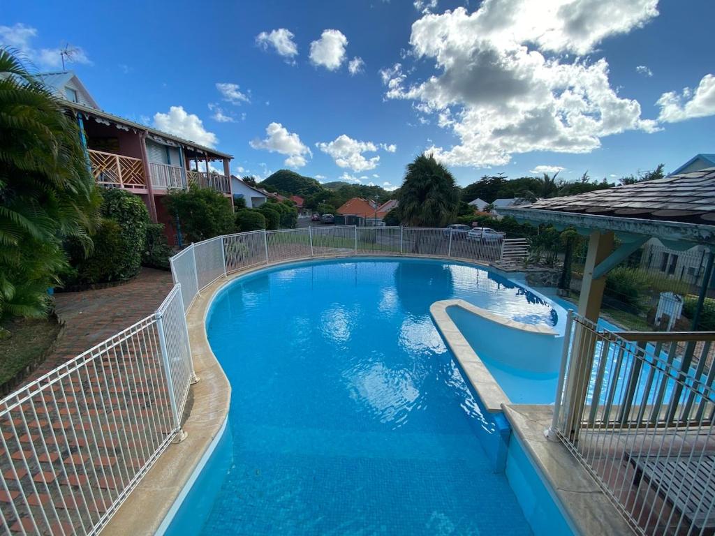 a large blue swimming pool with a fence around it at Camellia 2 Duplex in Sainte-Anne