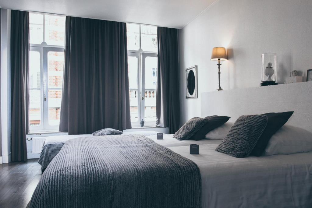 a hotel room with two beds and windows at Le Virage bistro en hotel in Maastricht