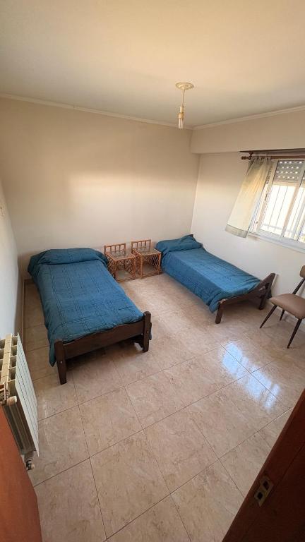 two beds in a room with blue sheets at Malvinas Casa de Playa in Necochea
