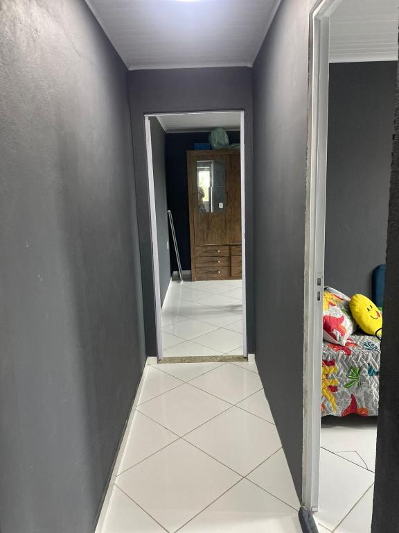 a hallway with a mirror and a bedroom at Lareaconchego in São Pedro da Aldeia