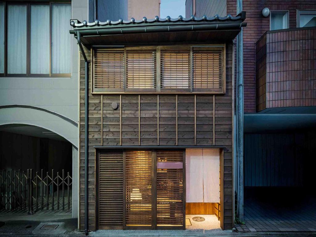 a building with wooden shutters on the side of it at Itose Machiya House in Kanazawa