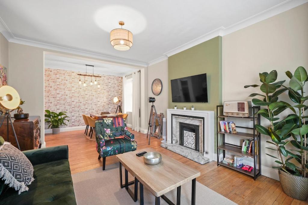 a living room with a couch and a fireplace at Spacious Modern 3 Bed Apartment in Hendon NW4 in Colindale