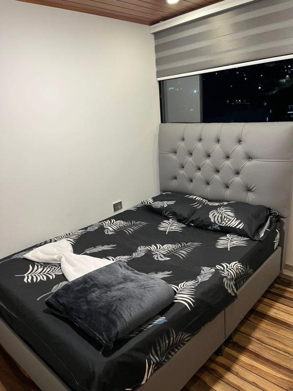 a bed with black and white sheets and pillows on it at Apto Domus in Pamplona