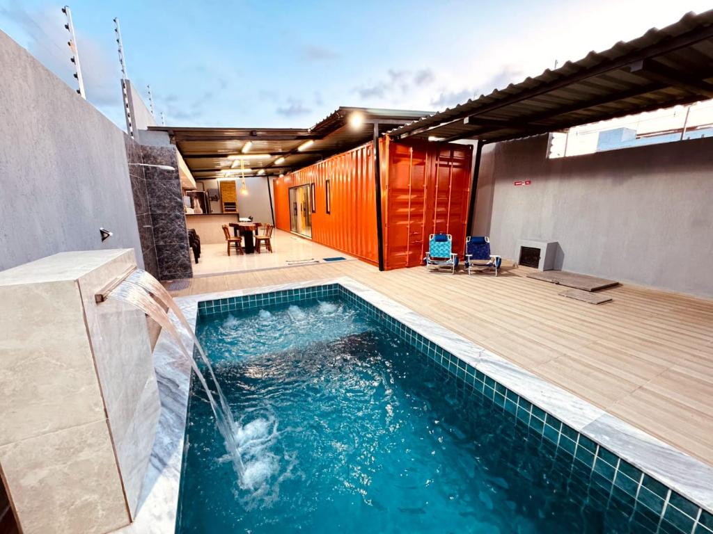 a swimming pool with a water fountain at CASA CONTAINER Vsa in Vitória de Santo Antão