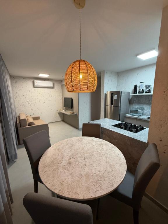 a kitchen and dining room with a table and chairs at Apartamento A03 - Curimã in Passo de Camarajibe
