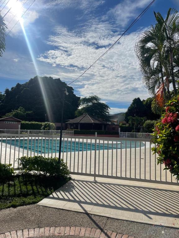 a swimming pool with a fence and a palm tree at Acogedor Apartamento Girardot in Girardot