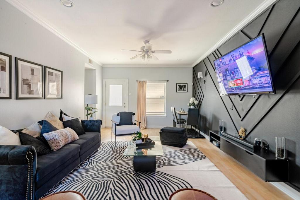 a living room with a couch and a flat screen tv at Fireside Double Kings Midtown Luxe Suite in Houston