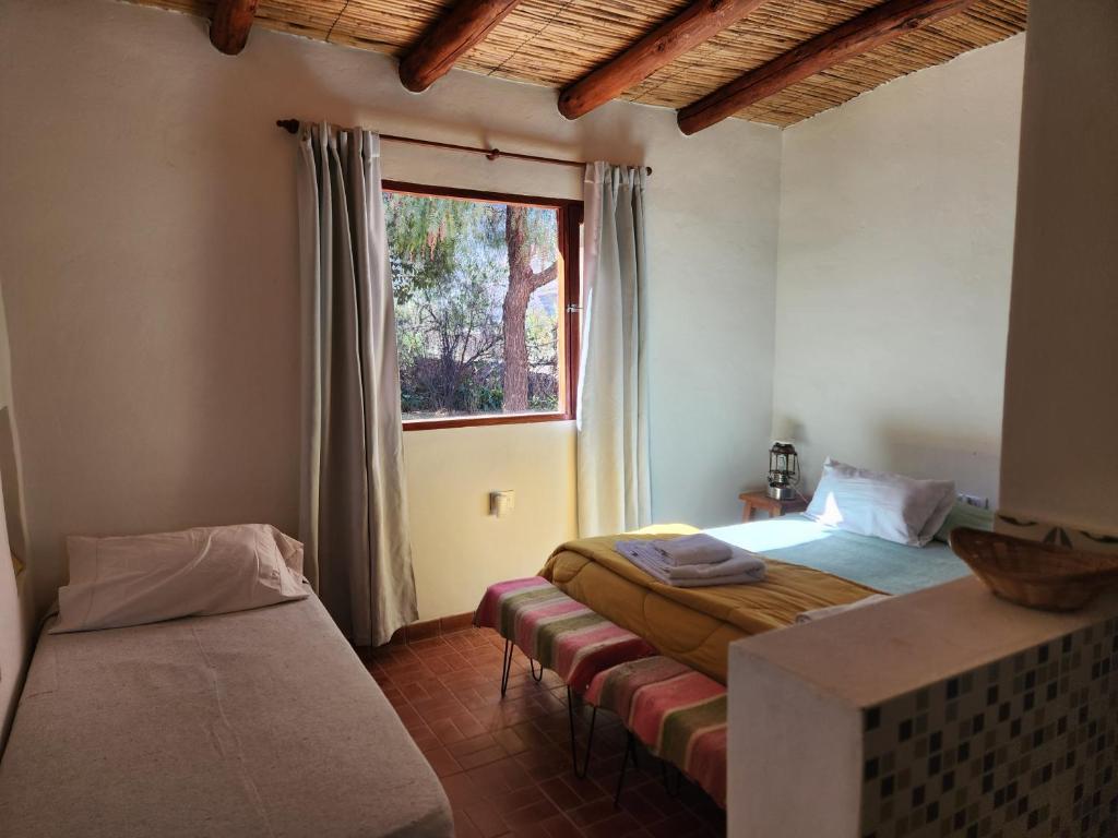 a bedroom with two beds and a window at Vivir en Maimará in Maimará