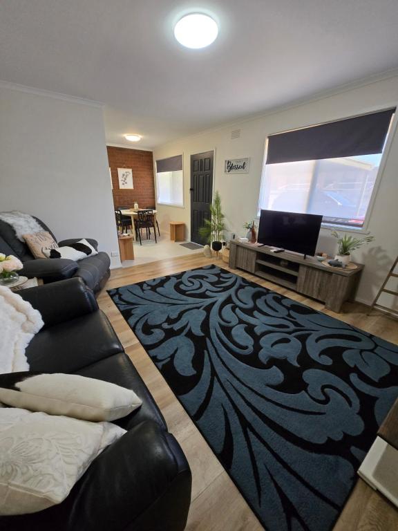 a living room with a couch and a flat screen tv at LBarza 1BR CBD Self Contained Apartment in Shepparton