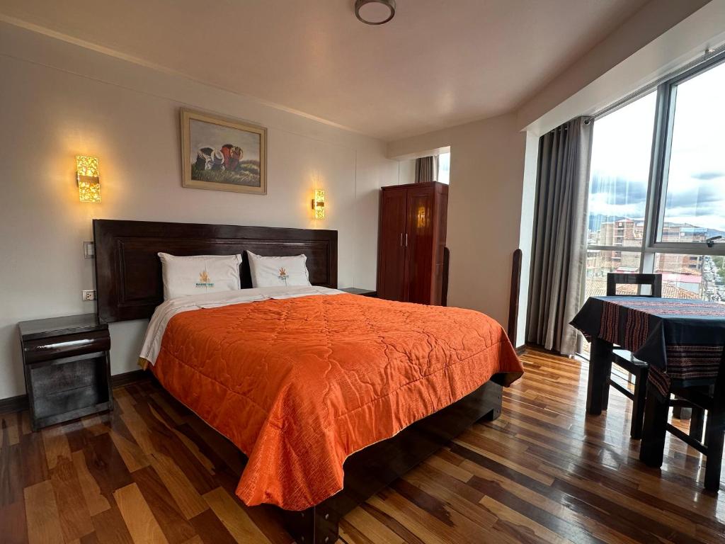 a bedroom with a bed with an orange bedspread at Hotel Inka Palace Huayna Ccapac Cusco in Cusco