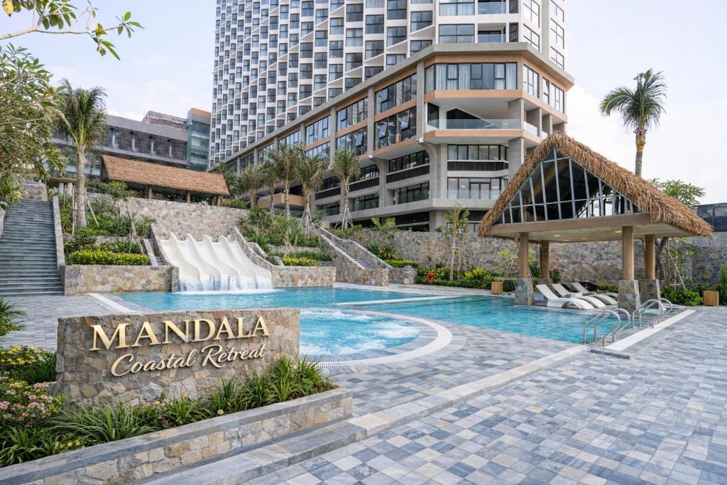 a swimming pool in front of a tall building at Mandala Coastal Retreat in Ấp Thiẹn Ái