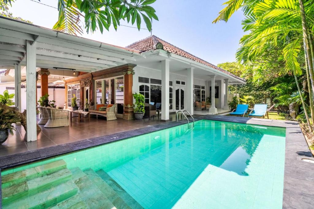 a villa with a swimming pool in front of a house at Alinta Villa 1 - Spacious Sanctuary in Sanur