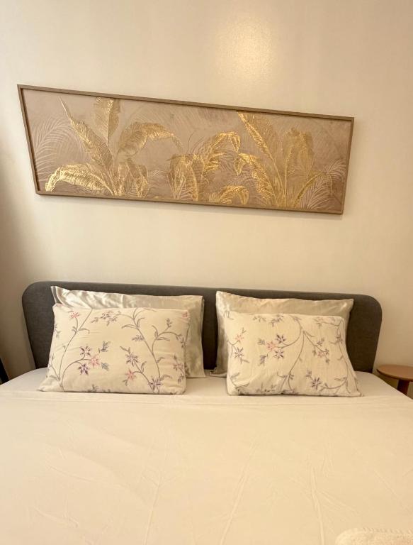 a bed with two pillows and a picture above it at 1 Bedroom Condo Unit at Centrio Tower in Cagayan de Oro