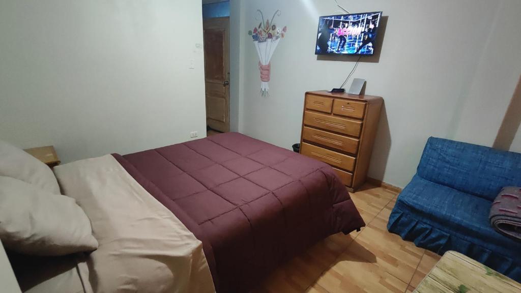 a bedroom with a bed and a dresser at Huachuma Rooms in Huaraz