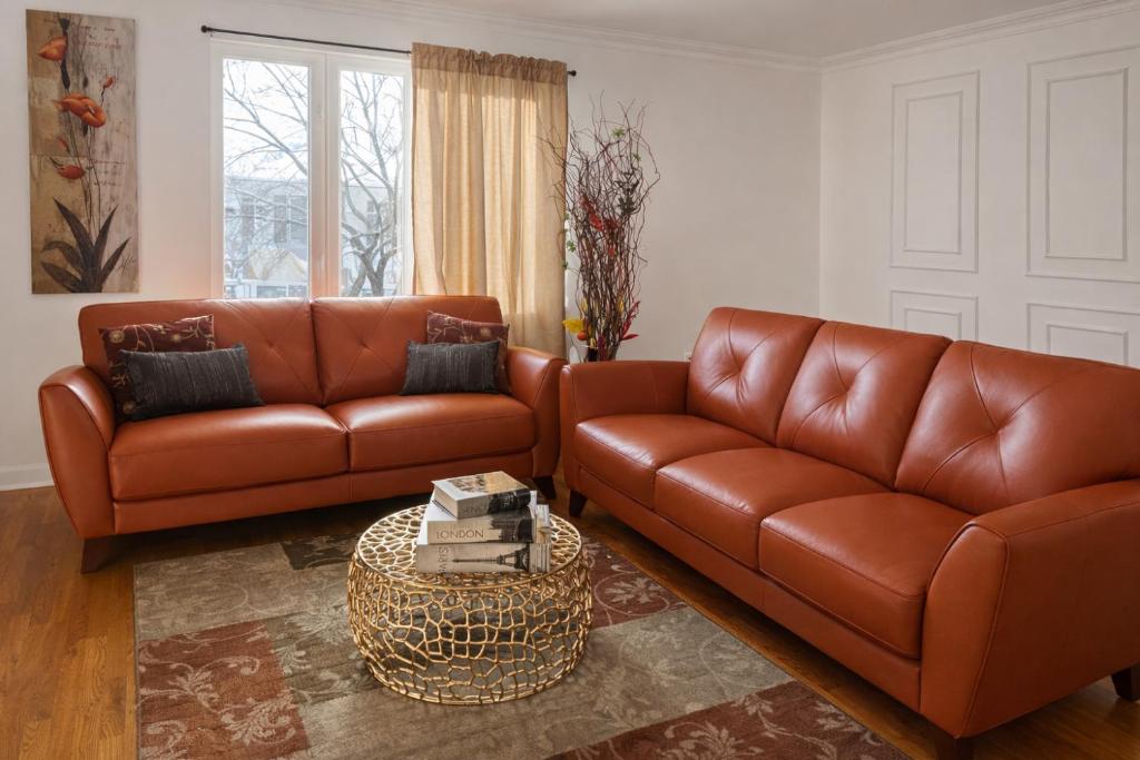een woonkamer met 2 bruine leren banken en een tafel bij Tremont Hidden Treasure in East Orange