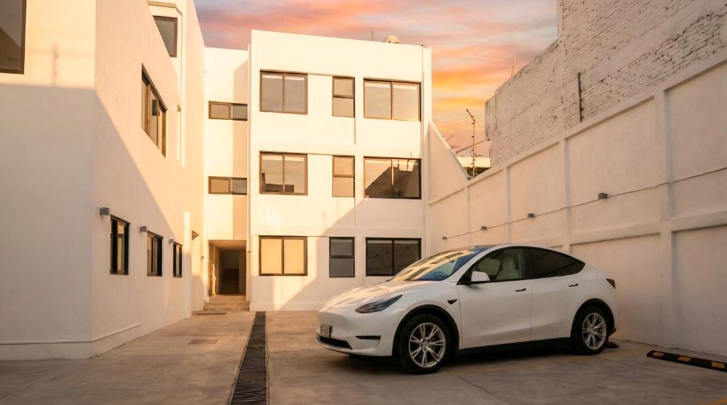 a white car parked in front of a building at Toronja C O V A D O N G A in Mexico City