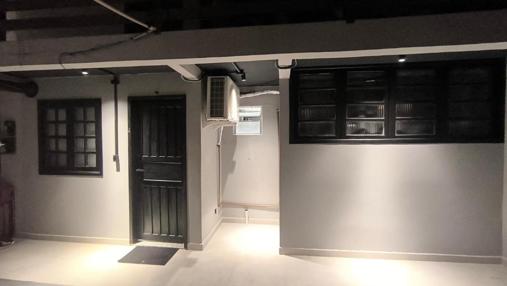 a room with black doors and a room with white walls at Studio de Praia in Matinhos