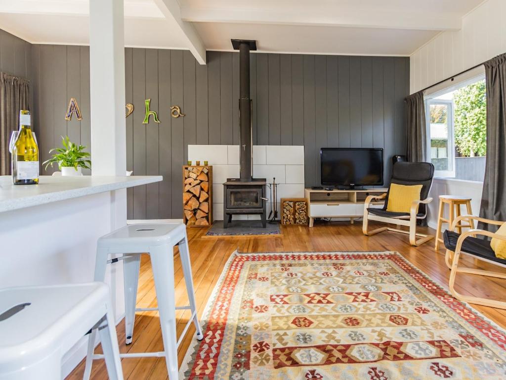 a living room with a fireplace and a stove at Aroha Cottage in Ohakune