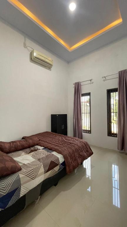 a bedroom with a bed in a room at Denggan KNO Guest House in Tanjungmorawa